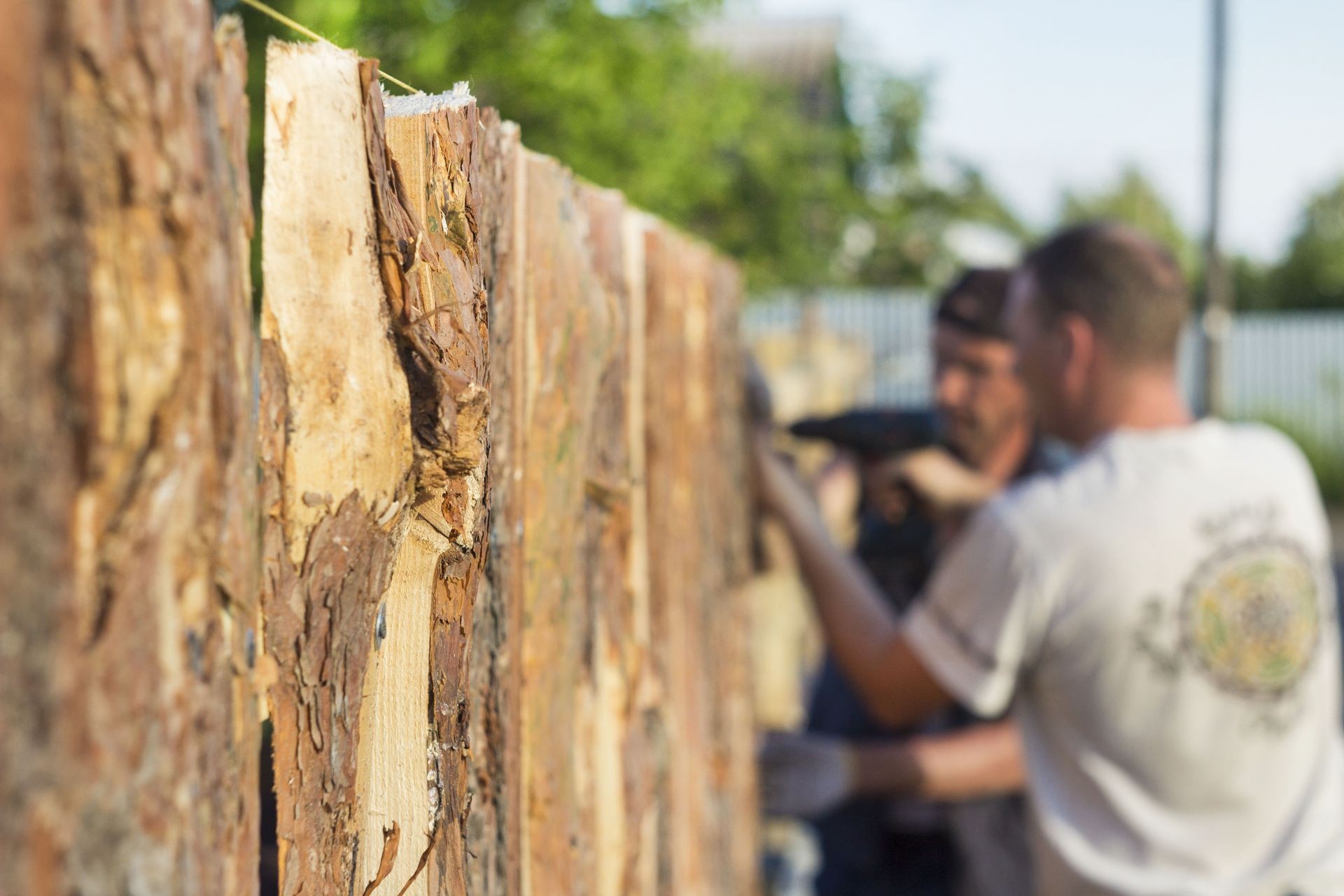 Construction of a new wooden fence. Workers builders in the background bokeh